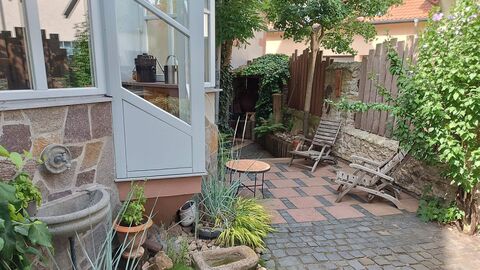 Auf dem Grundstück laden viele Sitzgelegenheiten zum Verweilen ein Gepflasterter Hof mit Holzstühlen
