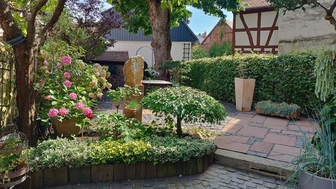 Zu dem Grundstück gehört ein mediterran gestalteter Garten Gepflasterter Innenhof mit Beeten