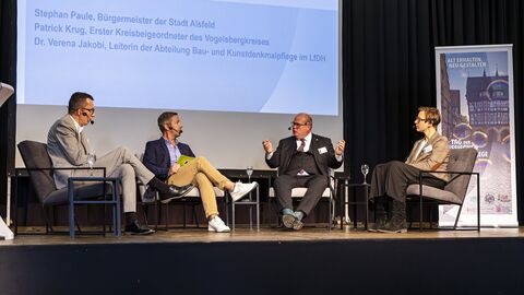 Neben mehreren Vorträgen gab es eine von Dirk Haberkorn (2. v. l.) moderierte Podiumsdiskussion mit Patrick Krug, Erster Kreisbeigeordner des Vogelsbergkreises, Stephan Paule, Bürgermeister der Stadt Alsfeld und Dr. Verena Jakobi, Leitung der Abt. Bau- und Kunstdenkmalpflege im LfDH. Von Links nach rechts: Patrick Krug, Dirk Haberkorn, Stephan Paule und Verena Jakobi bei der Podiumsdiskussion.