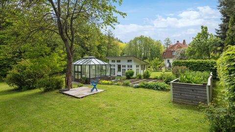 Garten mit Gewächs- und Gartenhaus Grünfläche mit mehreren Beeten und zwei kleinen Gebäuden