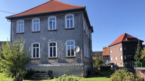 Gartenseite Verschindelte Fassade mit zwei Vollgeschossen und scht großen Segmentbogenfenstern