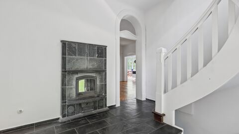 Eingangsbereich mit Kamin Weiß gestrichener Raum mit Kamin und Boden aus dunklem Stein