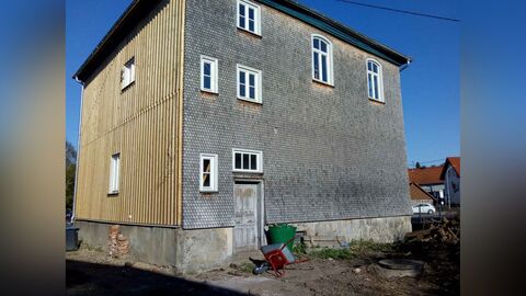 Rückseite mit Hintereingang Verschindelte Fassade mit Fenstern in verschiedenen Größen und Formen