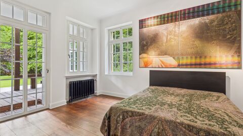 Gästezimmer Weiß gestrichener Raum mit Sprossenfenstern und Zugang zu einer Terasse