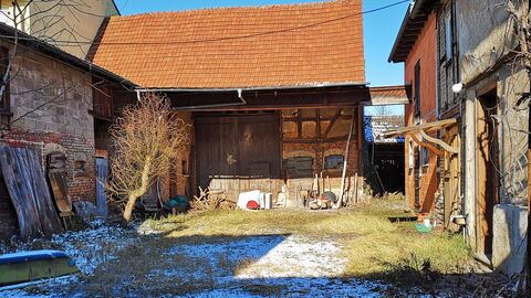 Zugewachsener Hof mit Fachwerkgebäude