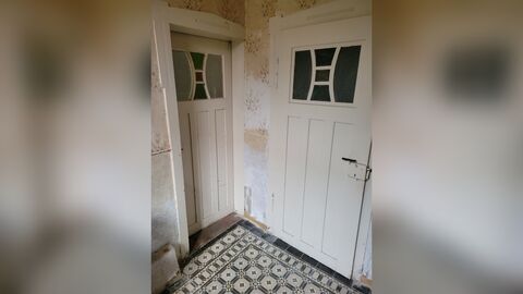 Zwei weiß gestrichene Türen, die von einem Raum abzweigen