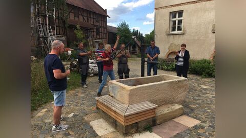 Helferinnen und Helfer weihen den Brunnen ein